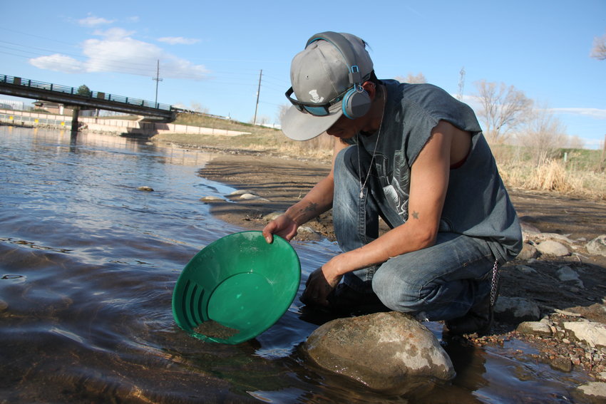 Elisandro Gonzalez pans for gold in the South Platte River. Gonzalez, a cook, was laid off in mid-March, and said goldpanning brings him peace and solitude in a chaotic time, even if it doesn't yield a payday.